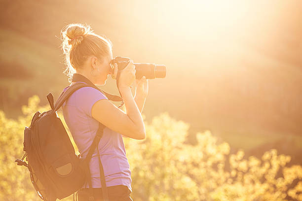 istock Woman taking photos outdoors on a sunny evening 531406516