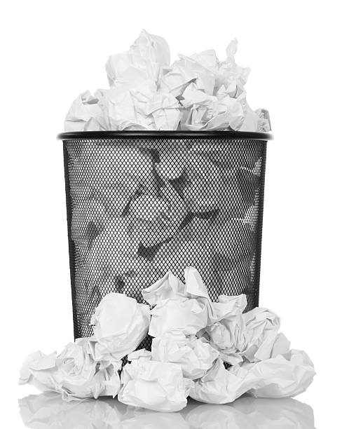 istock Metal trash can overflowing with paper waste isolated on white 531408226