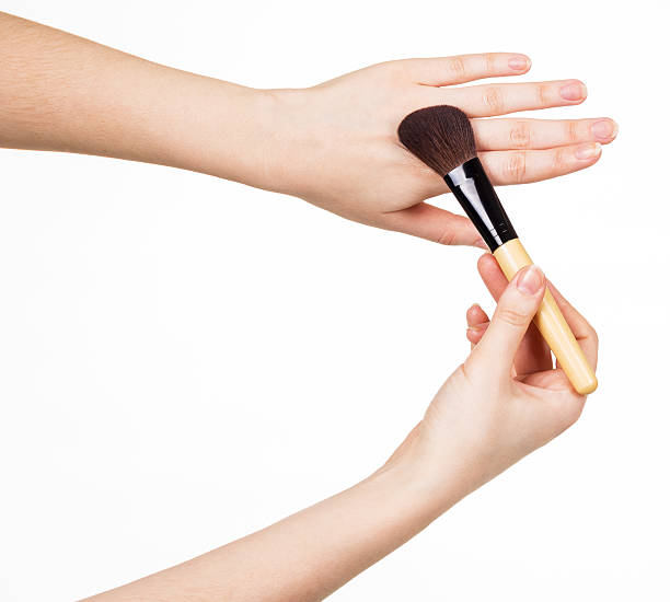 istock Cosmetic brush for makeup in  hands  women isolated on white 531408500