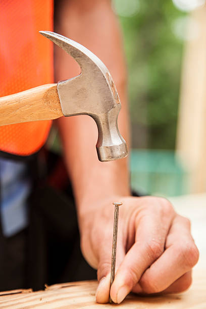 istock Construction worker working at job site, framed building. Hammer, nail. 531410464
