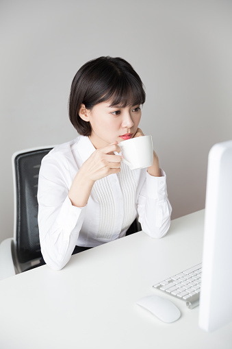 pretty girl sitting in the office drinking coffee