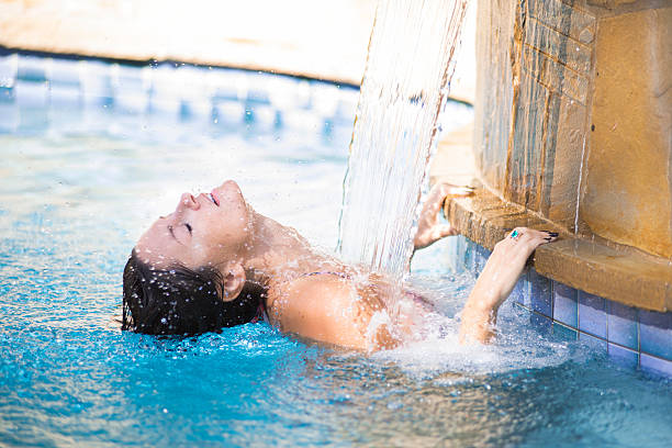 Beautiful young woman lounging in swimming pool stock photo