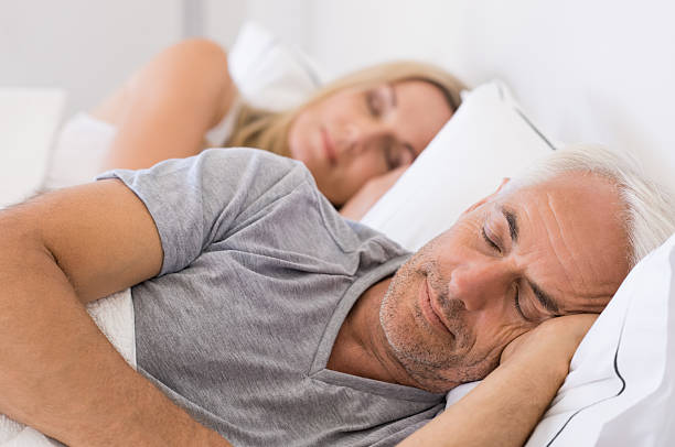 Couple sleeping in bed Senior man and woman sleeping. Senior man and woman resting with eyes closed. Mature couple sleeping together in their bed. double bed photos stock pictures, royalty-free photos & images