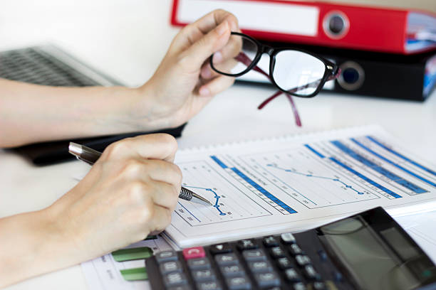 istock Businesswoman analyzing graphic and using calculator in the office 531415822