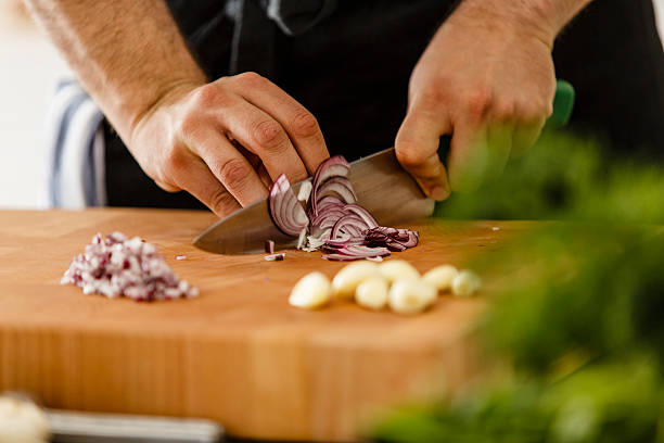 affettare cipolla rossa sul tagliere, primo piano - aglio alliacee foto e immagini stock