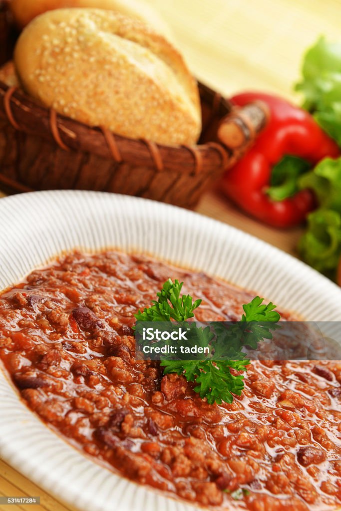 hot chili with Bowl of chili with peppers,  beans and  basket of bun Basket Stock Photo