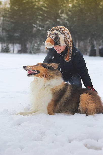 istock Boy playing with dog in snow 531417461