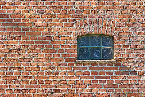 pequeno ferro celeiro vermelho janela na parede de tijolos - mullions - fotografias e filmes do acervo