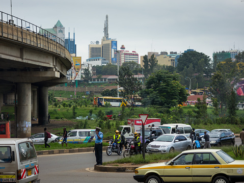 Nairobi, Kenya – May 13, 2016: A traffic policeman talks on his cellphone at a busy junction