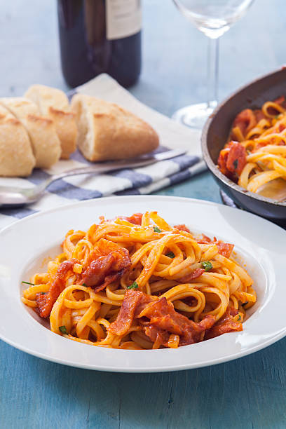 italian food amariciana style fetuccini with bacon and tomato sauce on white bowl all'amatriciana stock pictures, royalty-free photos & images