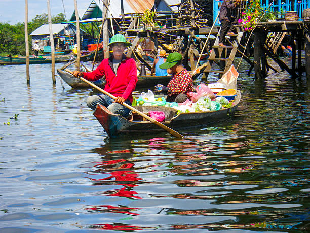 due persone in barca sul lago tonle sap, cambogia - flood people asia cambodia foto e immagini stock