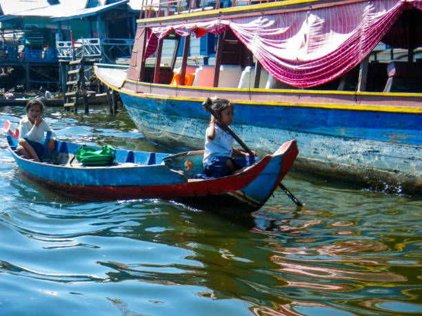 due bambini in barca sul lago tonle sap, cambogia - flood people asia cambodia foto e immagini stock