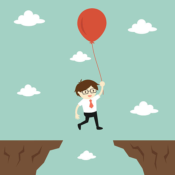istock businessman flies across a gap to another cliff 531423750