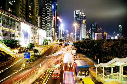 Causeway Bay, Hong Kong, at night with motion blurred vehicles travelling along the road. Central Plaza is visible in the background.  Hong Kong. 