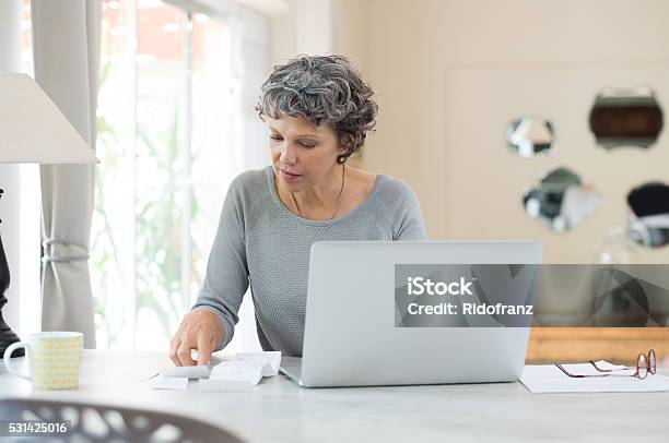 Senior Woman Checking Bills Stock Photo - Download Image Now - Financial Bill, Laptop, Finance