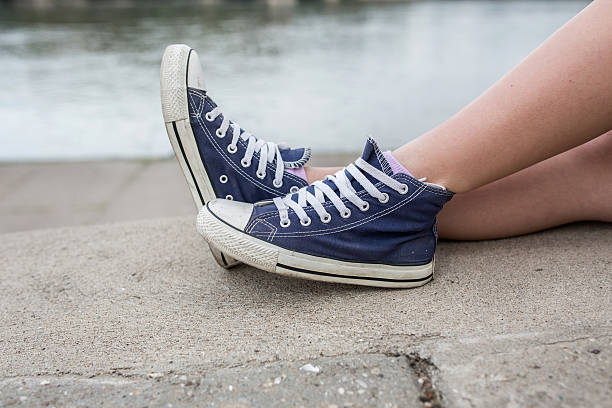 istock Unrecognizable woman's legs on a wall by the river. 531425304