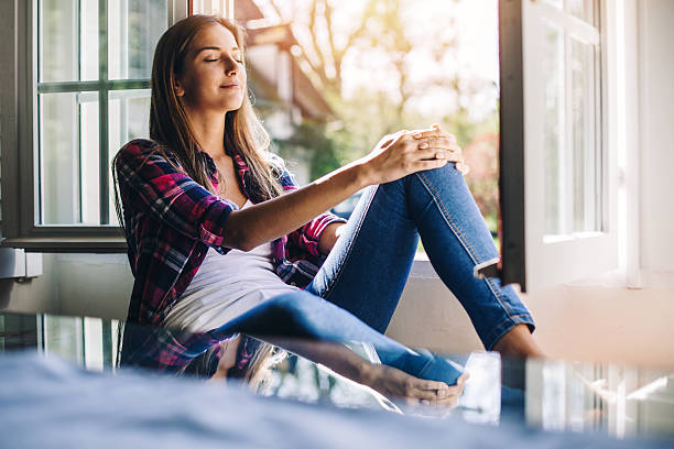 Relaxation Beautiful young woman sitting at a windowsill having rest and fresh air, with copy space and country side view. Shot made during Istockalypse Paris 2016 event. tranquil scene stock pictures, royalty-free photos & images