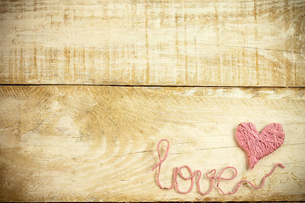 love Pink clew in shape of heart and word "love"on vintage wooden background knitting textile wool infinity stock pictures, royalty-free photos & images