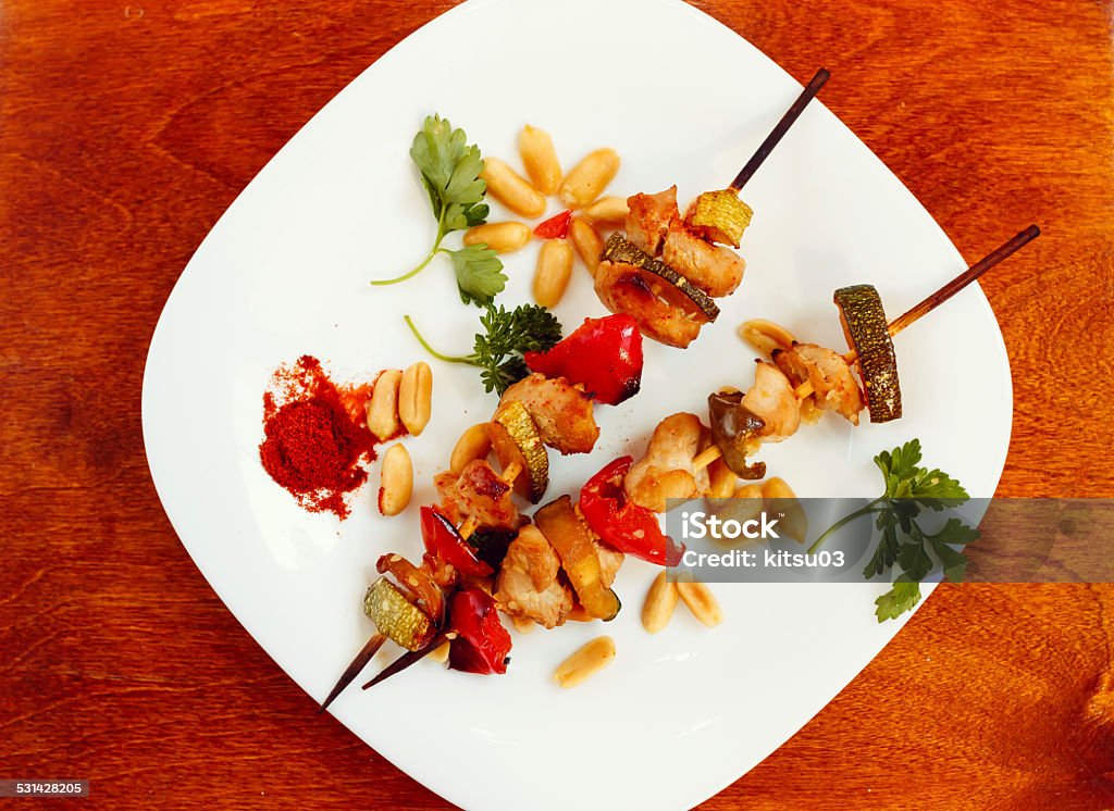 Chicken kebabs with pepper and zucchini Chicken kebabs with pepper and zucchini on wooden table 2015 Stock Photo