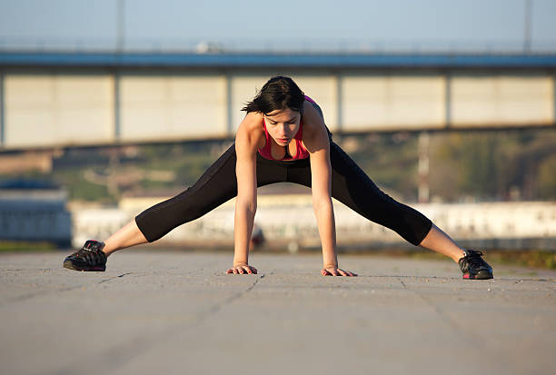istock Young woman stretching leg muscles with hands on floor 531429055
