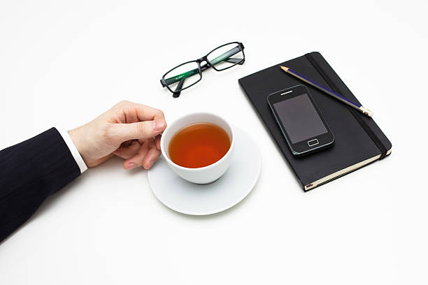 Businessman with cup of tea on white background stock photo