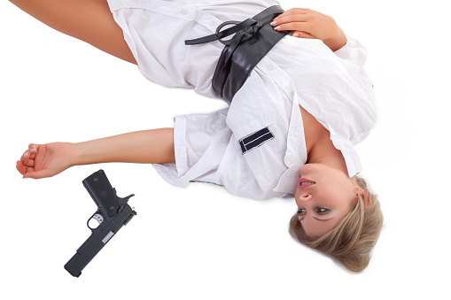 Woman lying on the floor with a gun near her