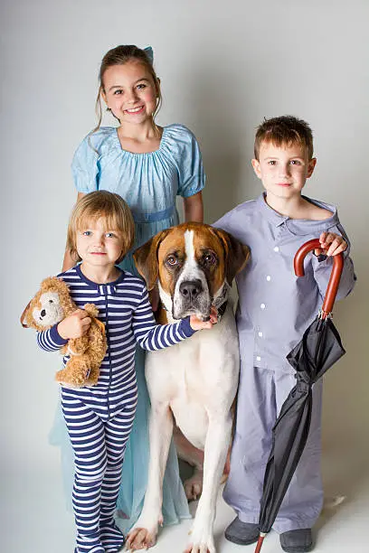 Three children dressed up as Wendy, John, and Michael from Peter Pan with there dog Nana.