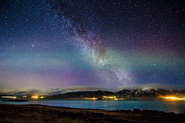 A typical Nordic nightscape and very famous location for travelers and adventurers from all over the world - Iceland with pale celestial lights Aurora Borealis and Milky Way galaxy above into the winter's night sky, which makes this Polar country a popular spot for tourist willing to witness one of the greatest natural phenomenoms. Shot with Canon EOS 60D, wide 11mm angle lens, f2.8, ISO 3200, long exposure of 30 seconds.