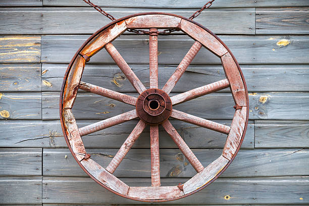 istock Old used wooden wheel hanging on rural wall 531442997