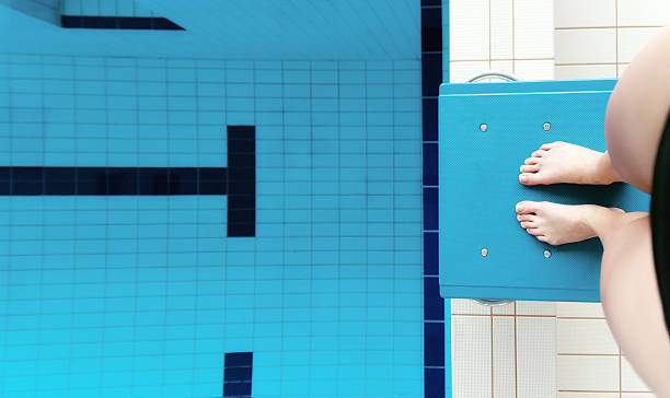 The Swimmer Female professional swimmer on the starting block. start block stock pictures, royalty-free photos & images