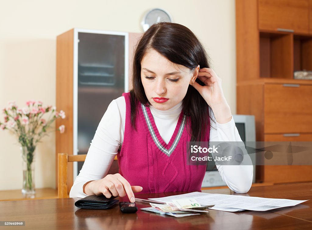 serious  woman calculating the family budget serious brunette woman calculating the family budget at  home 20-29 Years Stock Photo