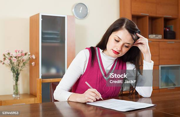 Serious Brunette Woman Reading Document Stock Photo - Download Image Now - 20-29 Years, Adult, Banking Document