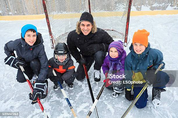 Family Playing At The Skating Rink In Winter Stock Photo - Download Image Now - 2015, 4-5 Years, 6-7 Years