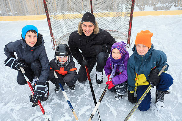 família brincando na pista de patinagem no inverno. - ice skating ice hockey child family imagens e fotografias de stock