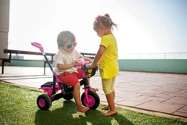 istock Cool boy sitting on tricycle and communicating with his sister. 531455010