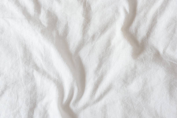 Top view of creased / wrinkles on unmade bed Top view of creased / wrinkles on a white unmade / messy bed sheet after waking up in the morning. Bedsheet is not neatly arranged for new guests or customers to sleep in. Abstract texture background sheet stock pictures, royalty-free photos & images