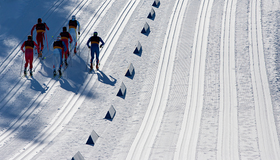 A group of six men head to the finish line in a cross-country ski race.