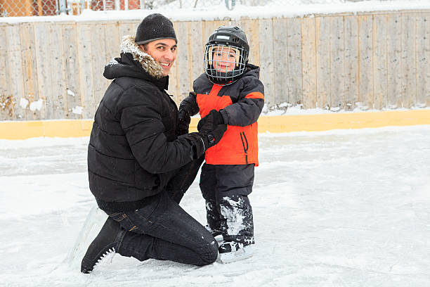 familie spielen auf der schlittschuhbahn im winter. - ice skating ice hockey child family stock-fotos und bilder