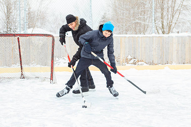 istock family playing at the skating rink in winter. 531459607