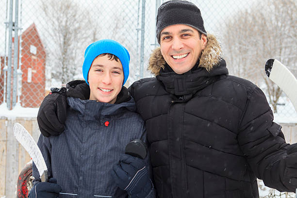 familia jugando en la pista de patinaje en invierno. - ice skating ice hockey child family fotografías e imágenes de stock