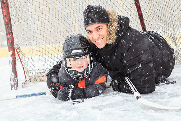 familie spielen auf der schlittschuhbahn im winter. - ice skating ice hockey child family stock-fotos und bilder