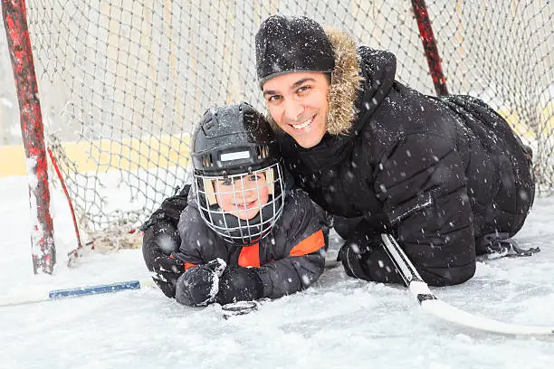 Photo of family playing at the skating rink in winter.