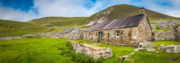 Renovated stone cottage sitting amongst the ruins of the abandonded Village street on the remote island of Hirta in the St. Kilda archipelago far off the Scottish coast in the North Atlantic, a rare double UNESCO World Heritage Site. ProPhoto RGB profile for maximum color fidelity and gamut.