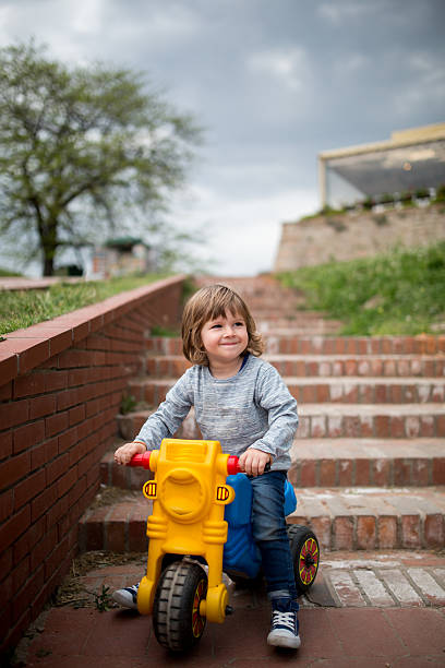 Portrait Of Smiling Boy Holding Toy By Wall