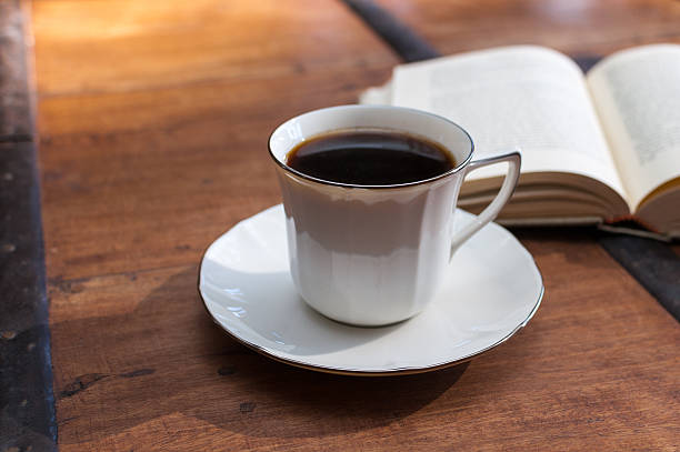 istock Cup of coffee and open book on a wooden table 531460281