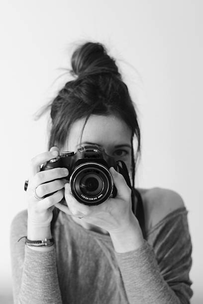 istock Young female photographer with camera on soft background 531461201