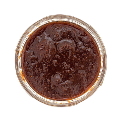 Top view of an opened jar of wild strawberry preserves isolated on a white background.