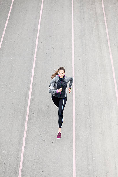 istock Young woman jogging on sport track 531462470