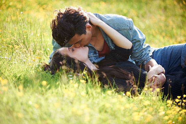 Get a room! Cute young couple lying in a field outside and kissinghttp://195.154.178.81/DATA/shoots/ic_781479.jpg teen romance stock pictures, royalty-free photos & images