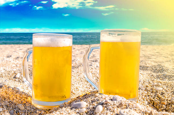 istock Two cold beer bottle in the sand on the beach 531463592
